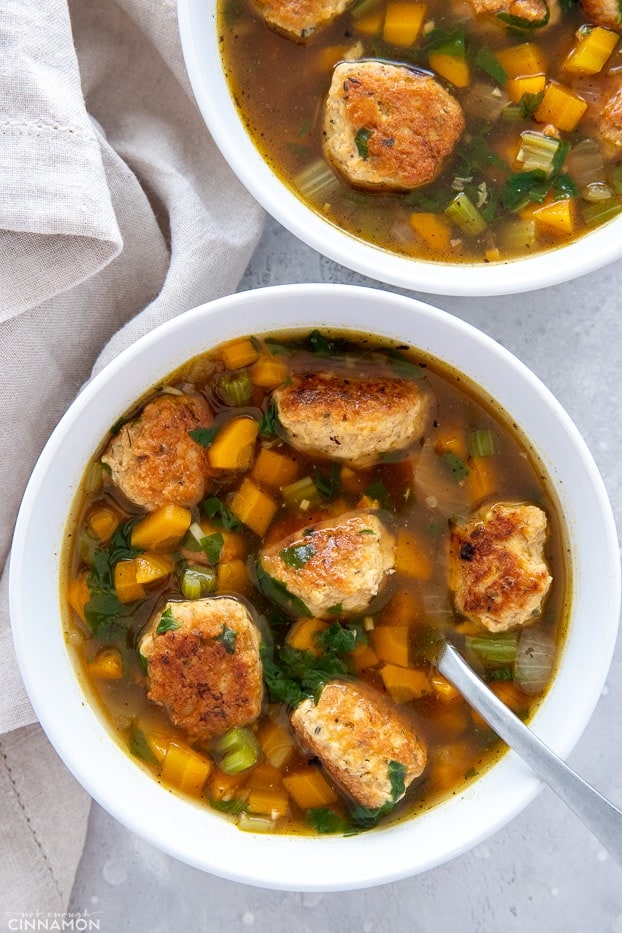 a bowl of Italian Wedding soup with a spoon inserted 