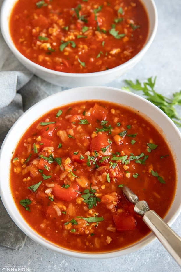 two bowls with healthy bell pepper soup with a spoon inserted 