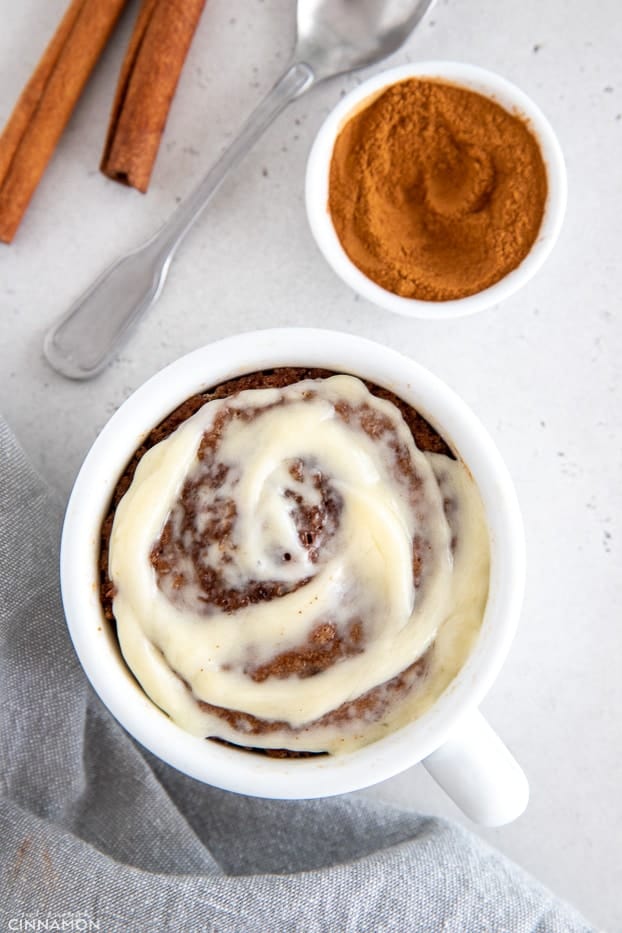 overhead shot of healthy cinnamon roll mug cake with cream cheese frosting