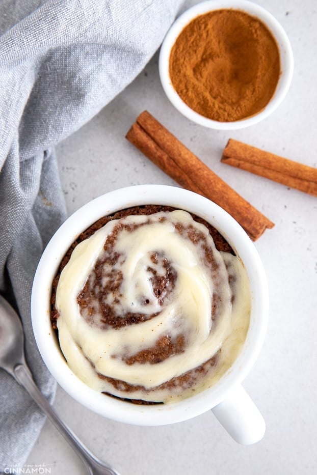 overhead shot of healthy cinnamon roll mug cake with cream cheese frosting