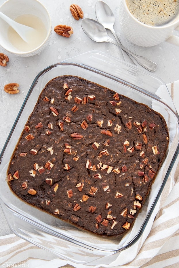 overhead shot of a baking dish with vegan gingerbread baked oatmeal with a bowl of icing on the side