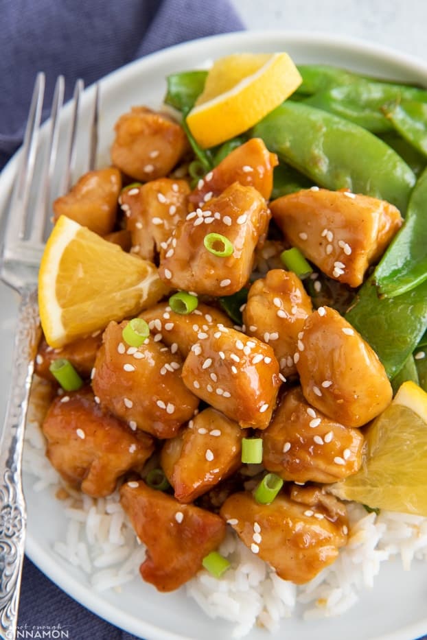 one skillet Chinese orange chicken served with rice and greens 