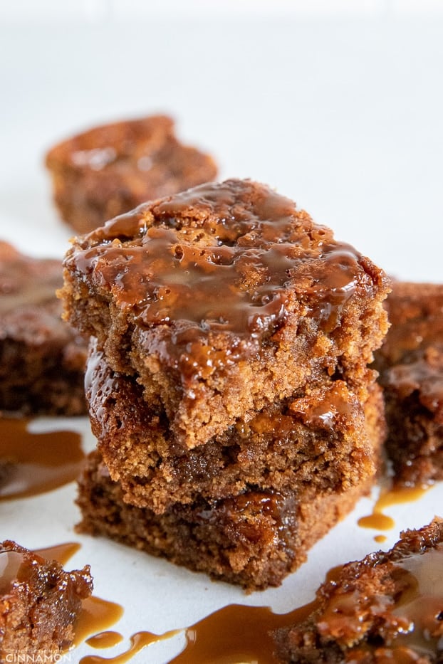 stacked healthy salted caramel blondies drizzled with coconut caramel