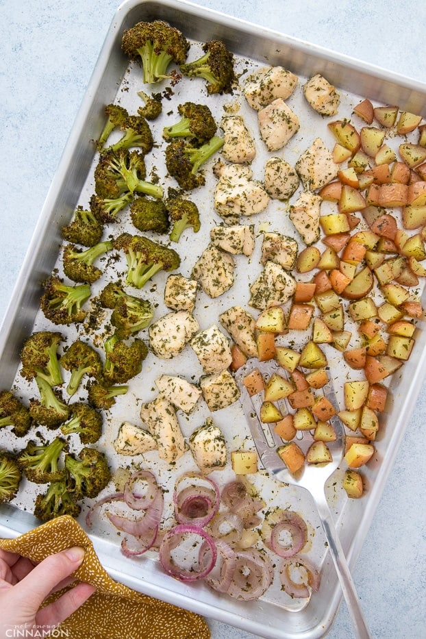 a sheet pan with chicken breast, onion, potatoes and broccoli seasoned with homemade paleo ranch seasoning