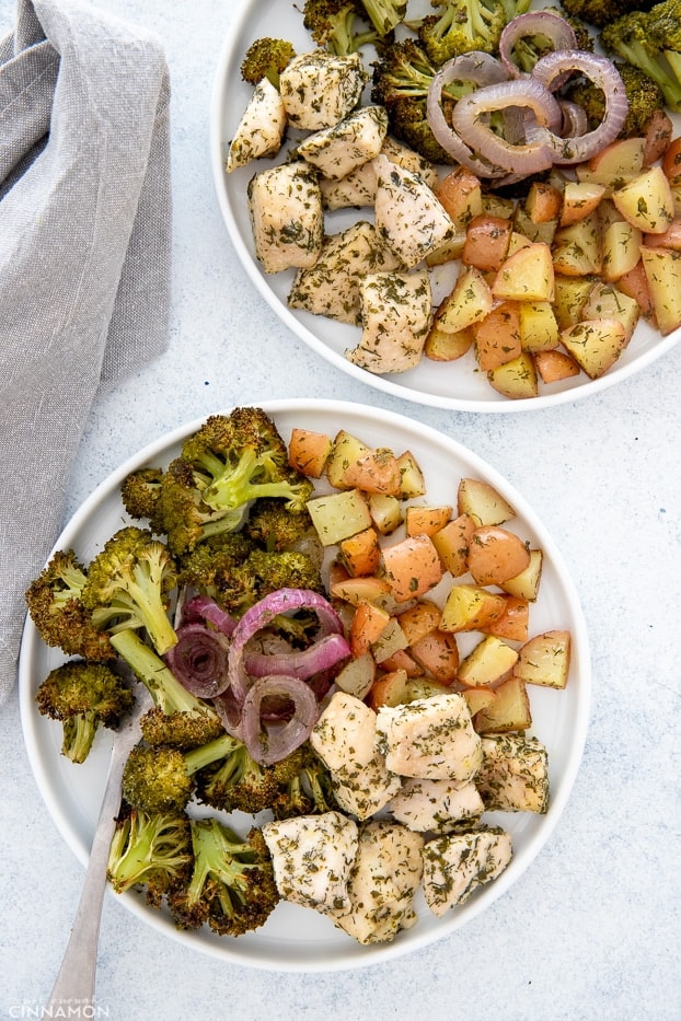 two plates with baked vegetables and chicken breast baked with ranch seasoning 