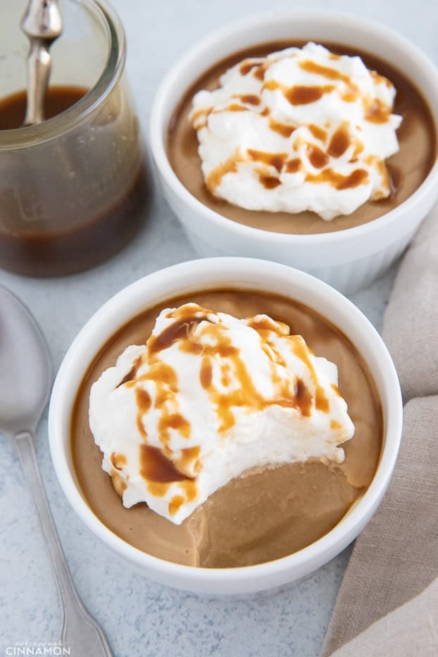 overhead shot of vegan salted caramel pudding topped with coconut whipped cream