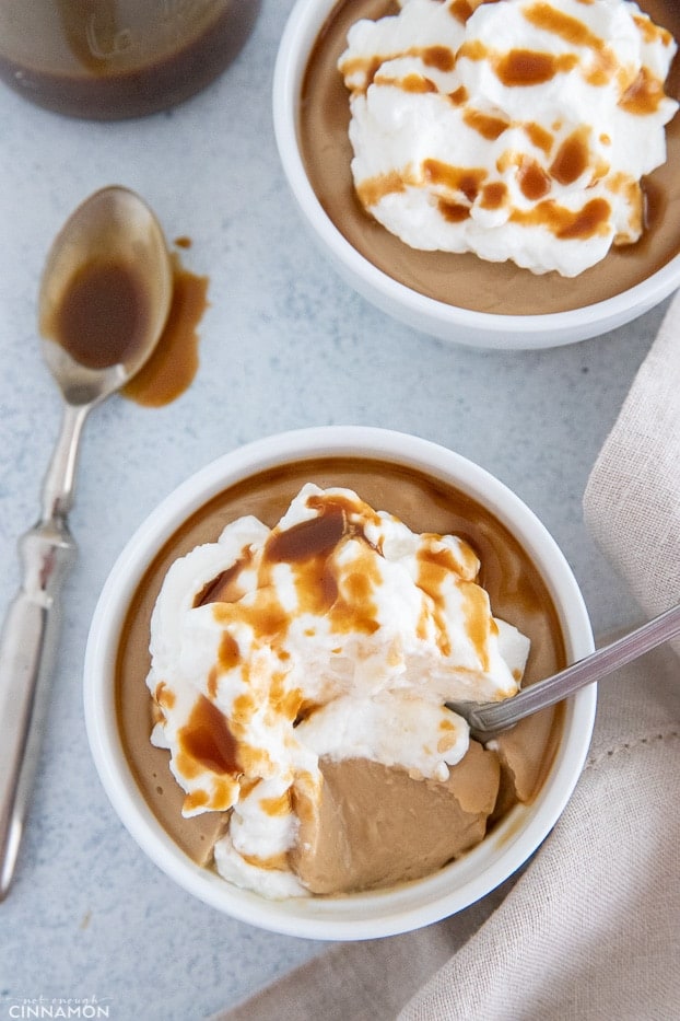 a spoon being inserted into smooth vegan salted caramel pudding 