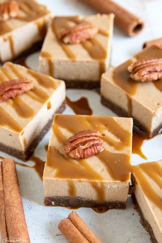 no bake vegan chai cheesecake bars topped with pecan halves and drizzled with coconut caramel 