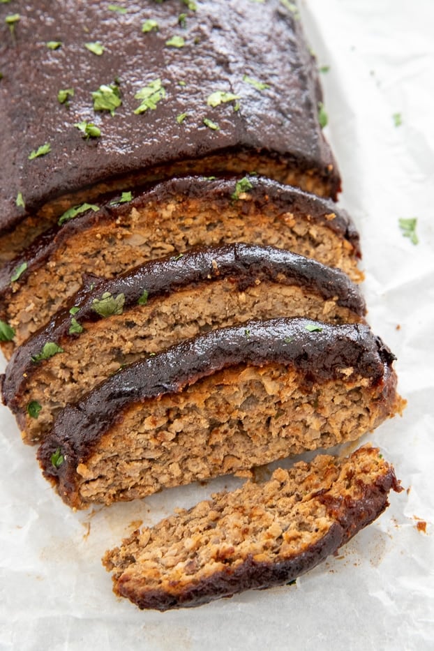 a juicy bbq glazed paleo ground turkey meatloaf being sliced into pieces 