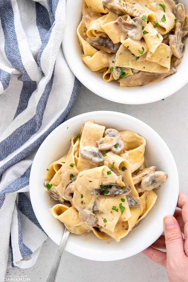 two plates of vegan mushroom stroganoff on a white table