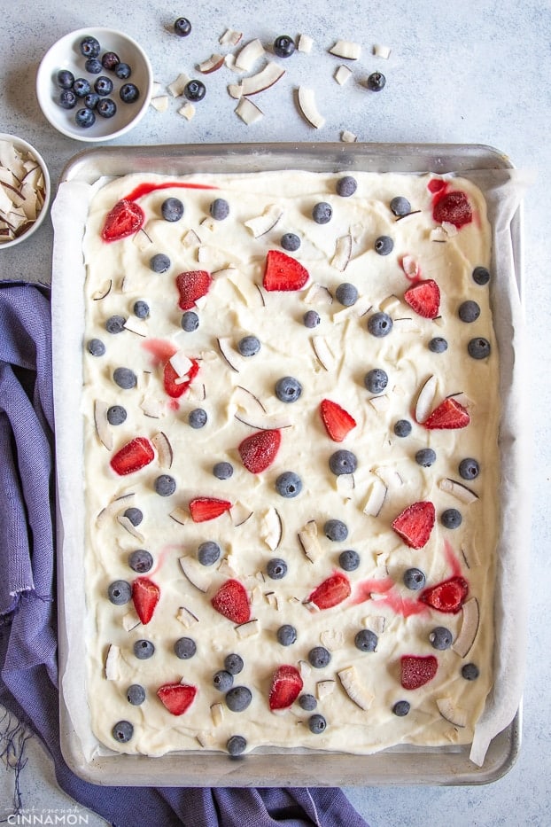healthy frozen yogurt bark on a baking sheet surrounded with assorted toppings
