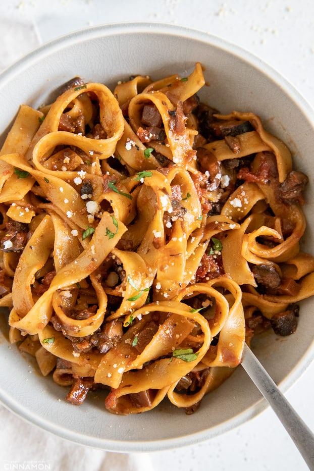 vegan mushroom bolognese tossed with fettuccine pasta in a pasta bowl 