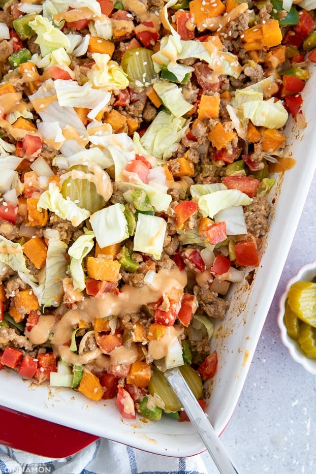 a sliver spoon being stuck into a casserole dish with healthy burger casserole 