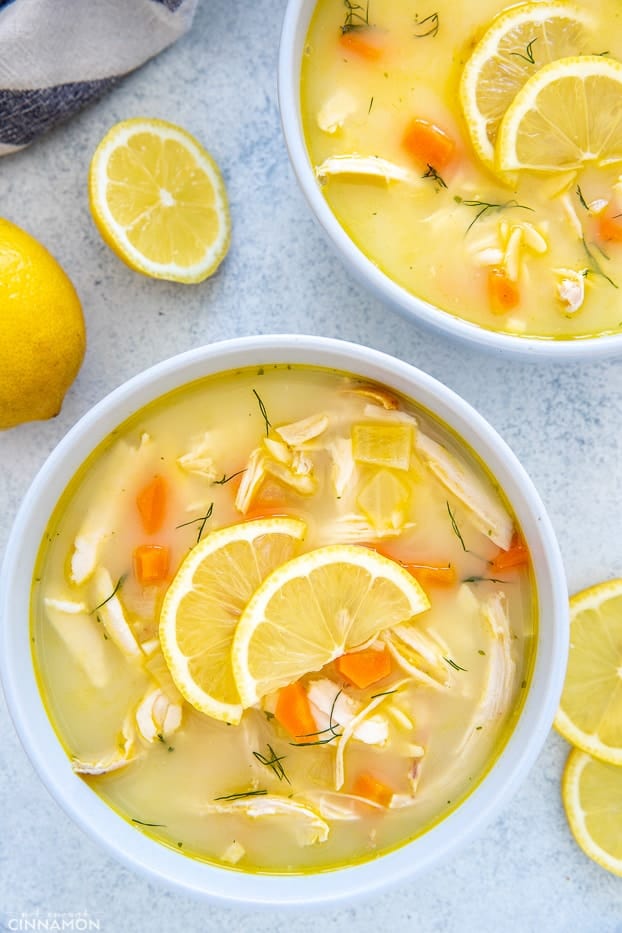 two bowls with Greek Lemon Soup with Greek orzo pasta and shredded rotisserie chicken