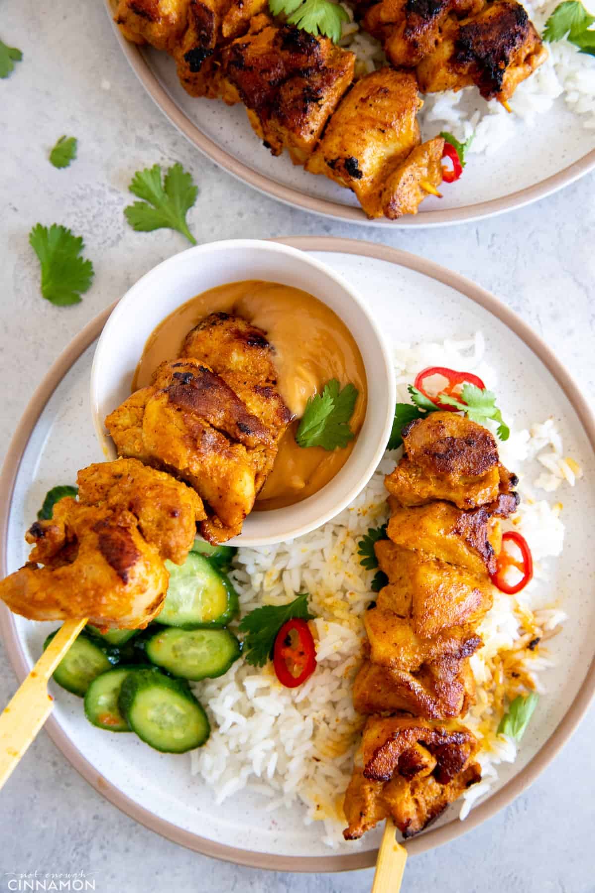 homemade chicken skewer being dipped into satay peanut sauce 