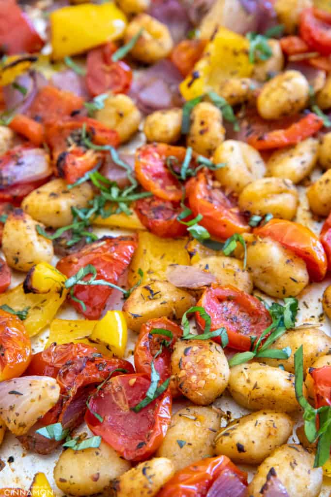 crispy baked gnocchi, cherry tomatoes and bell pepper on a sheet pan 