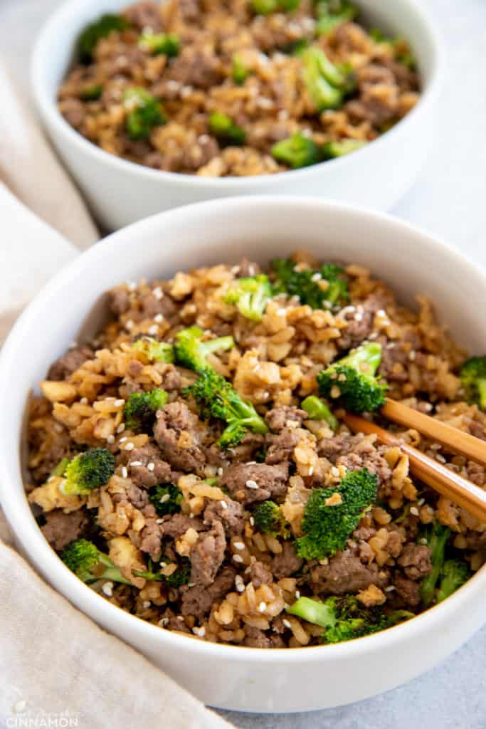 side view of beef and broccoli fried rice with chopsticks on the side