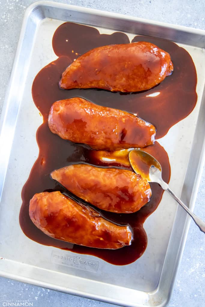 chicken breasts on a sheet pan smothered with healthy firecracker sauce