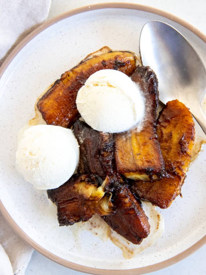 a plate with healthy banana foster topped with vanilla ice cream