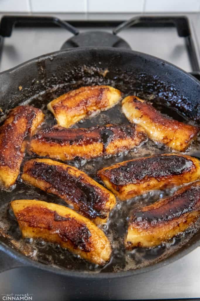 banana caramelizing in rum caramel sauce in a skillet 